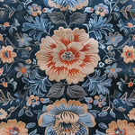 A close-up view of the Verdant Tapestry Hand Tufted Rug showcasing its intricate floral design. This vintage wool area rug features vibrant blue and orange flowers against a dark background, perfect for enhancing any dining room with elegance and style.