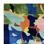 The Verdant Terrain Collage Hand Tufted Rug, a stunning area rug perfect for contemporary living room spaces. This large living room rug features an abstract design with vibrant hues of green, blue, orange, and pink, crafted from high-quality wool, adding a modern touch to any room.