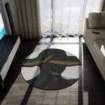 Vibe Split Round Rug with abstract black and gold pattern on dark wood floor in modern room with TV unit and sofa