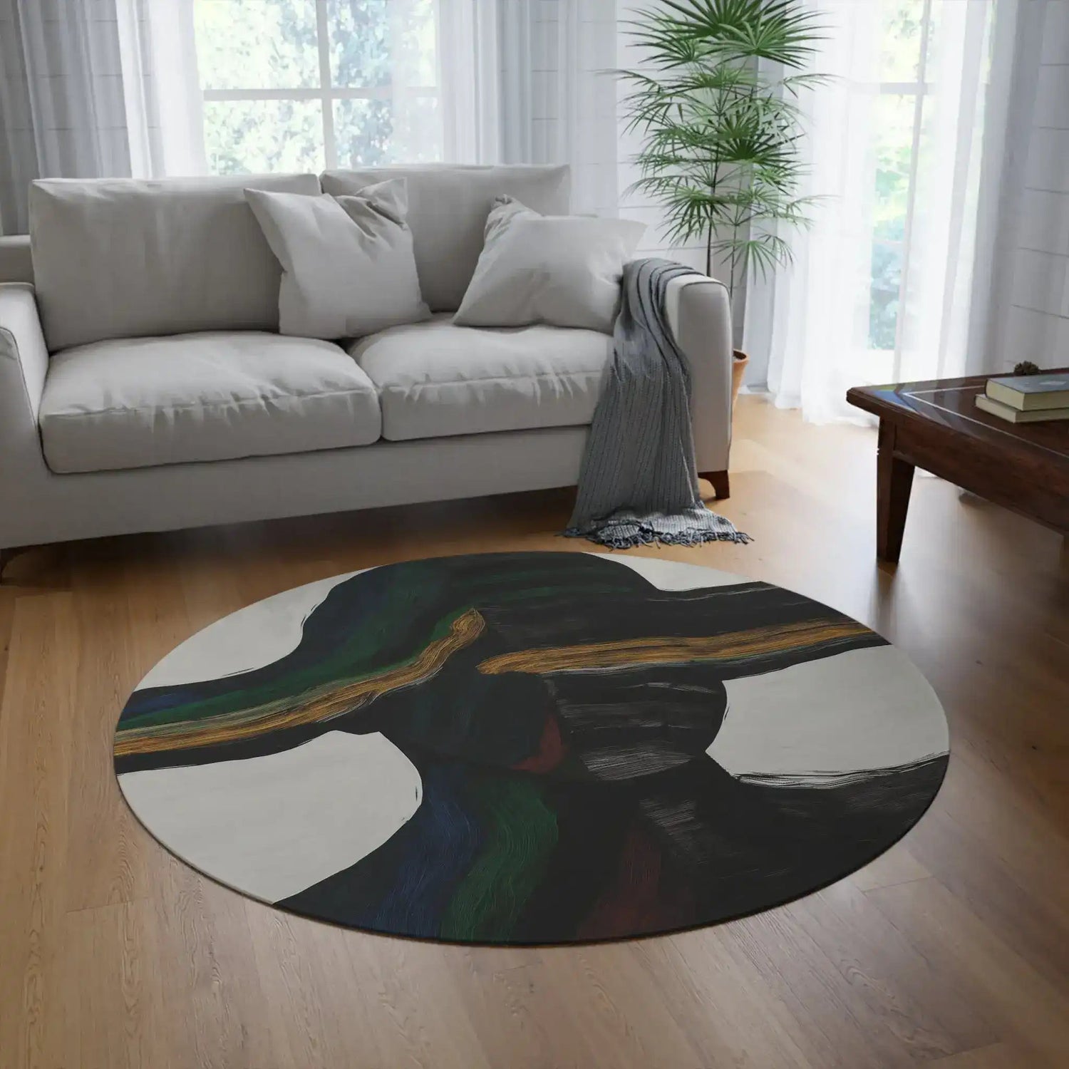 Vibe Split Round Rug with bold abstract black and gold brushstroke pattern placed in bright living room in front of a grey sofa