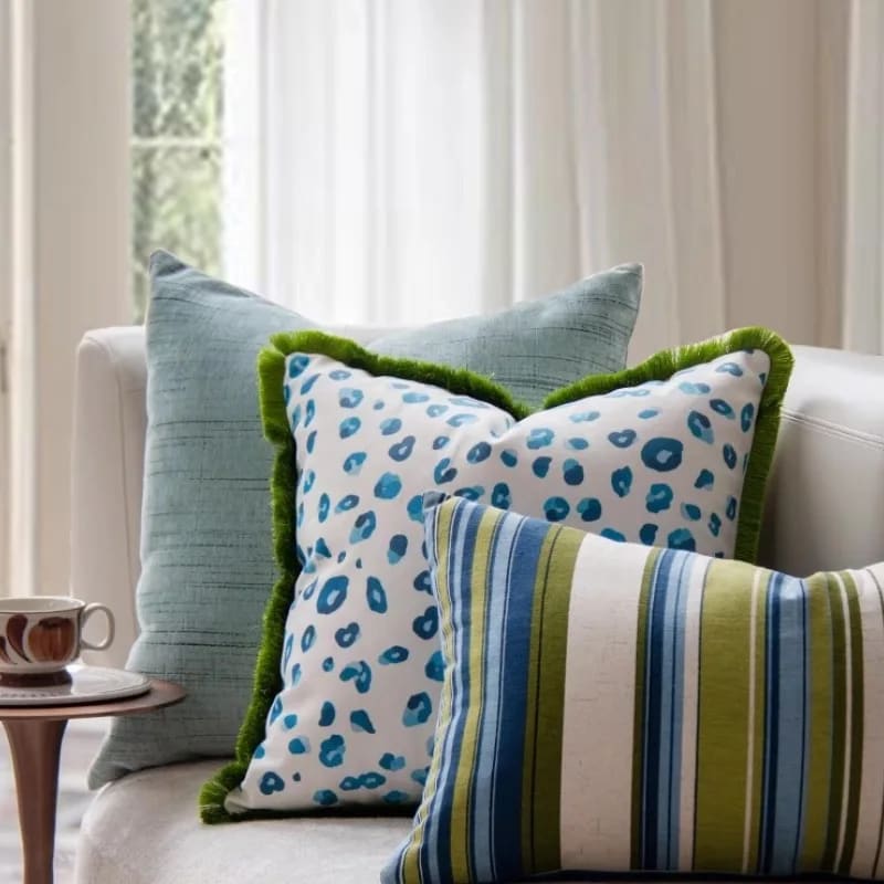 Vibrant aquatic leopard throw pillow cover featuring a playful blue leopard print on a white background, complemented by a green fringe, perfect for adding a pop of color to your home decor.