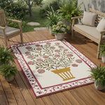 Decorative rug with floral pattern on a wooden deck surrounded by plants and furniture.