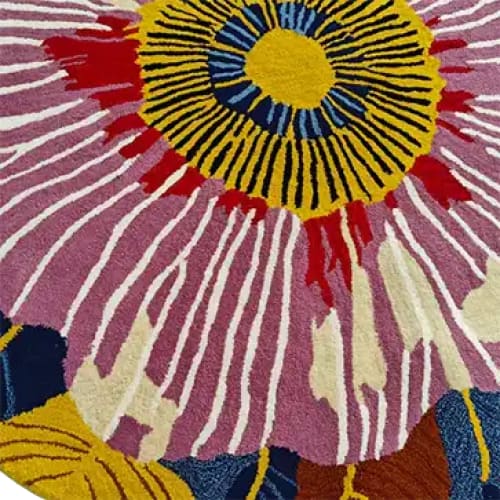 Close-up view of a vibrant bloom tapestry hand tufted round area rug, showcasing a bold floral design with a mix of yellow, pink, and blue hues. Perfect for adding a splash of color to a dining room or as an elegant wool rug option for office spaces. This floral round rug combines style and function, making it an ideal choice for modern office rugs.