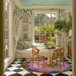 Bright and colorful floral area rug in a dining room setting. The round wool rug features vibrant bloom patterns, adding a lively touch to the office or any space. Perfect for those seeking unique rugs for office or dining areas.