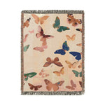 Vibrant Butterfly Woven Blanket flat lay from wider angle — cream woven throw with scattered butterflies in blue, pink, teal, and golden hues with fringed border