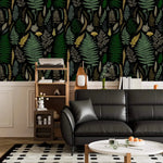 Vibrant fern canopy wallpaper above white wainscot with black leather sofa and ladder shelf