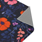 Folded corner of Vibrant Floral Embroidered Accent Rug showing orange and pink flowers on dark navy, angled corner view with grey backing