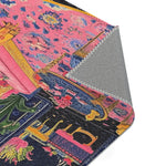 Folded corner of the Vibrant Maximalist Floral Rug showing grey non-slip back and pink-blue oversized floral face pattern with gold leg detail