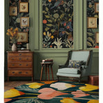 Elegant living room featuring a vibrant meadow hand tufted round area rug with bold floral patterns. The rug, perfect for dining or living rooms, adds a pop of color with its wool texture and round shape, complementing the classic decor and floral wallpaper.