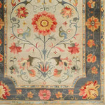 A vibrant and intricately designed hand-knotted area rug featuring a stunning floral pattern, reminiscent of traditional Persian rugs. This large living room rug, ideal for an 8x10 space, showcases a rich tapestry of colors with a dominant central flower and a detailed border, perfect for adding elegance and modernity to any home.