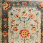 Close-up view of the Vibrant Modernity Hand Knotted Area Rug, showcasing intricate floral patterns inspired by traditional Persian rugs. This large living room rug, sized 8x10, features a harmonious blend of vivid colors set against a neutral background, perfect for enhancing any modern decor.