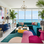 Modern living room with ocean view, colorful furniture, a contemporary wool rug, and decorative elements.
