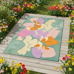 Colorful floral-patterned rug on a wooden deck with flowers around