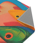Angled corner fold of the Vibrant Vision Surreal Girl & Multicolor Fish Art rug revealing orange and green fish heads against pink, grey anti-slip backing visible