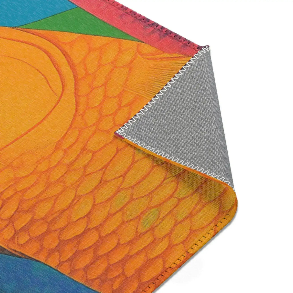 Close-up orange fish body scales on a curled corner of the Vibrant Vision Surreal Girl & Multicolor Fish Art rug with grey anti-slip backing