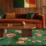 A beautifully vibrant area rug with floral patterns in a large living room setting. The wool rug features a lush green background with pink flowers, adding elegance to the square area rug. It's perfectly placed under a wooden coffee table in a cozy living room, complementing the warm tones of the surrounding decor.