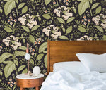 Dark floral wallpaper with white blooms in bedroom with wood headboard, white bedding and nightstand
