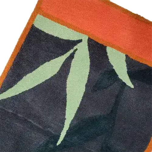 Close-up view of the Dark Night Hand-Tufted Area Rug, showcasing its abstract leaf design in green against a dark background, bordered with a rich orange trim. Perfect for large living rooms, this wool rug is available in 8x10 size, adding a touch of elegance and warmth.