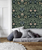 Vine and flower wallpaper in deep teal with symmetrical green Art Nouveau vines and pink blooms; floor bed and white paneled wall