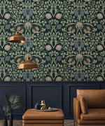 Vine and flower wallpaper above dark navy molding panels with tan leather armchair and twin copper pendant lights