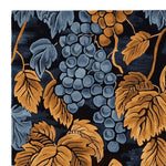 Close-up view of the Vine Noir Hand Tufted Area Rug, showcasing its intricate vintage design with blue grapes and golden leaves. This wool rug is perfect for enhancing the aesthetic of living room spaces, especially in the popular 8x10 size. Ideal for those seeking stylish and durable rugs for living room decor.