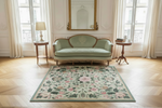 Decorative rug with floral pattern in a room with a sofa and side tables.