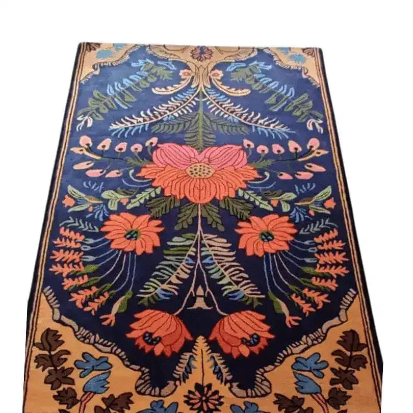 A beautifully detailed vintage Aurum Garden hand-tufted area rug showcasing vibrant floral patterns in orange and green on a deep blue background. This wool rug is perfect for adding a touch of elegance to your living room. Ideal for living room rugs 8x10, this vintage floral rug enhances the aesthetic appeal of any living room area.