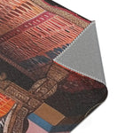 Folded corner of the Vintage Bohemian Woven Rug exposing grey anti-slip backing, rust and dark geometric pattern and carved bench side visible