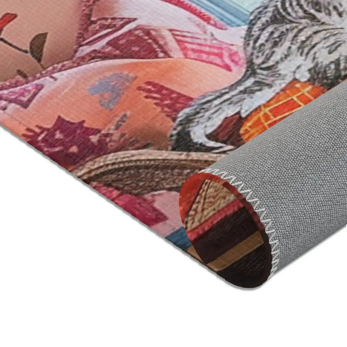 Rolled corner of the Vintage Bohemian Woven Rug, peach-pink floral cushion and cat paw partially visible, terracotta woven face at top