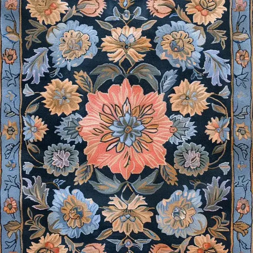 The Vintage Bouquet Hand Tufted Rug features a rich floral pattern in vibrant blues, pinks, and oranges on a dark background. This wool area rug, reminiscent of Persian rugs, adds elegance to any living room or formal dining room setting, making it a perfect choice for those seeking a vintage touch.