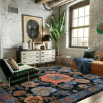 A cozy living room showcasing a Vintage Bouquet Hand Tufted Area Rug. This elegant floral rug, reminiscent of Persian rugs, features vibrant flower patterns in hues of pink, blue, and beige, adding warmth to both the living room and dining room spaces. The wool rug sits under a green armchair and an orange sofa, creating a stylish and inviting atmosphere, perfect for formal dining room settings.