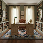 Home office with wooden desk, a floral wool rug, bookshelves, and decorative elements.