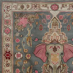 Close-up view of a Vintage Elephant Hand Knotted Area Rug featuring intricate designs with an elephant motif, floral patterns, and warm colors. Perfect for large living rooms, this Persian wool rug adds a touch of elegance and charm to any space. Ideal as a square rug for living room settings, fitting well as an 8x10 square area rug.