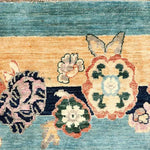 Close-up of a Vintage Floral Bordered Chinoiserie Blue Wool Hand Knotted Area Rug, showcasing intricate floral patterns in vibrant colors on a textured blue background. Ideal for adding elegance to large living room spaces, this living room area rug combines traditional craftsmanship with timeless design.