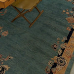 Close-up of a vintage floral bordered Chinoiserie blue wool hand-knotted area rug, perfect for large living rooms. The rug features intricate floral patterns on a rich blue background, showcasing its elegance as a living room area rug.