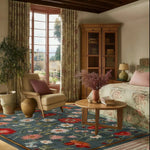 A cozy living room featuring a Vintage Floral Delight Hand Tufted Wool Rug. This large area rug, perfect for a living room, showcases a vibrant floral design with red and white blooms on a blue background. The room is elegantly furnished with a comfortable chair, a wooden coffee table, and a large window letting in natural light, enhancing the beauty of the wool rug. Ideal for adding a touch of elegance to any living space.