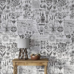 Vintage herbal alchemy wallpaper showing botanical sketches and script behind a rustic console with lamp