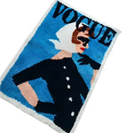 A vibrant area rug featuring a vintage magazine cover design with a stylish woman in a black outfit and sunglasses, set against a bold blue background. Perfect for adding a touch of retro flair to living room area rugs and enhancing any area rugs for living room collection.