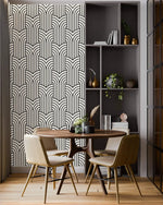 Vintage ornate outline wallpaper feature wall, black art deco arches on cream beside a round dining table