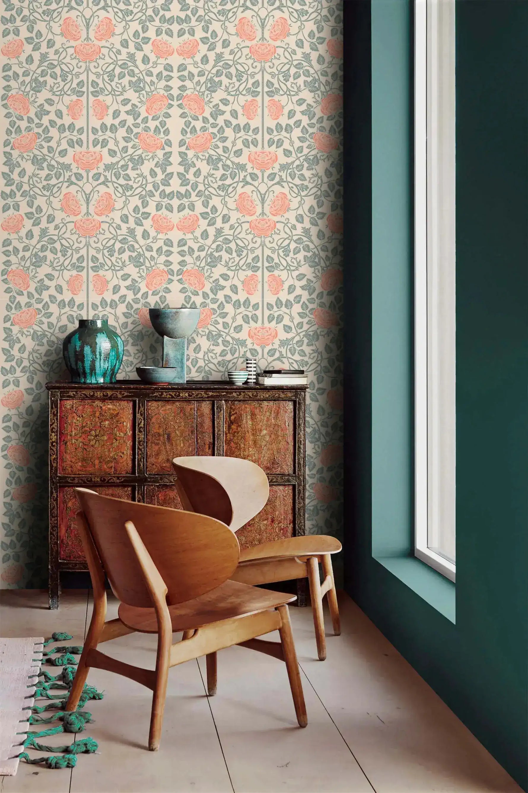 Vintage rose garden wallpaper by a window with carved cabinet, coral roses on sage vines, cream ground