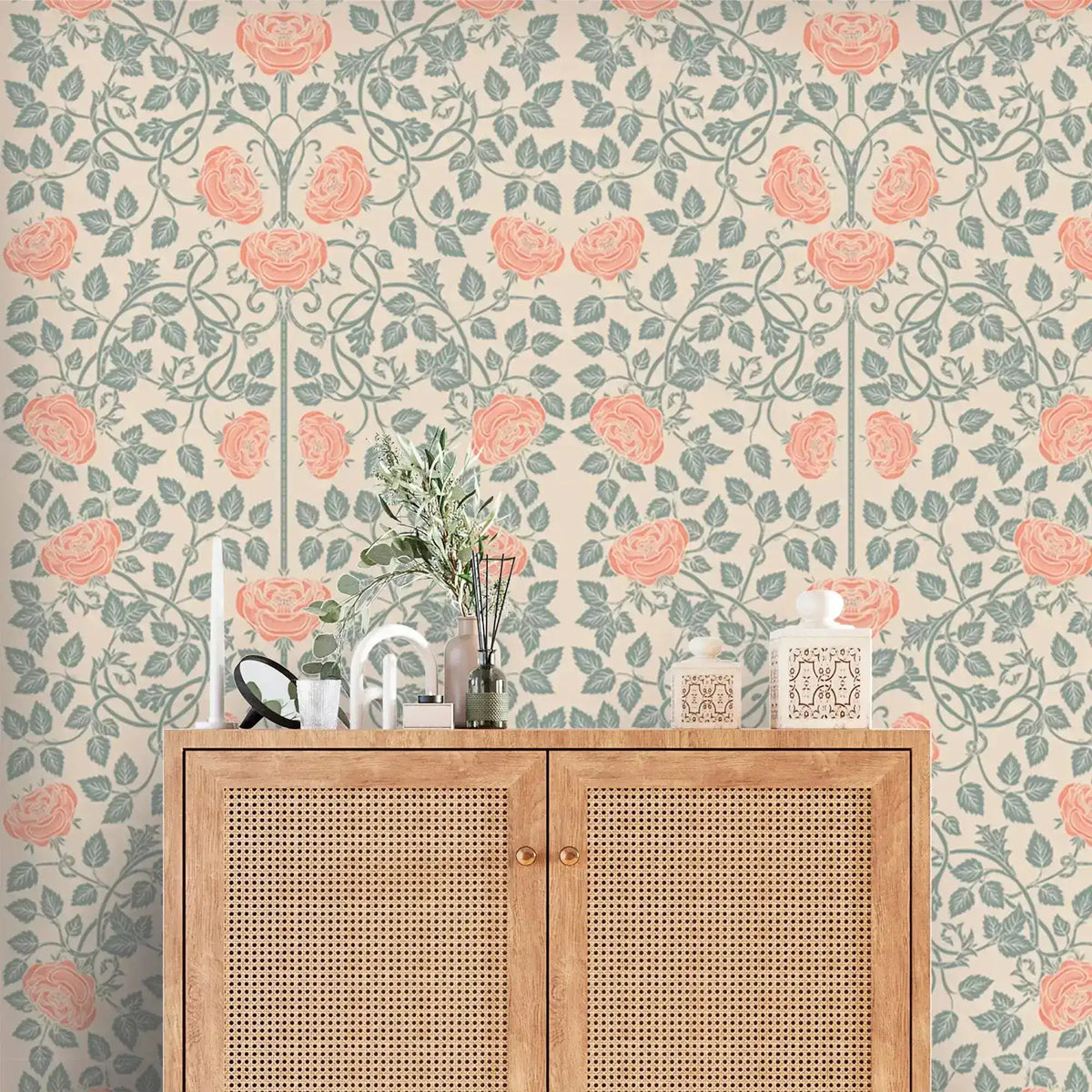 Vintage rose garden wallpaper, coral roses on sage trellis vines over cream, above a cane cabinet