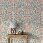Vintage rose garden wallpaper styled with wood table and lamp, coral roses on sage vines, cream ground