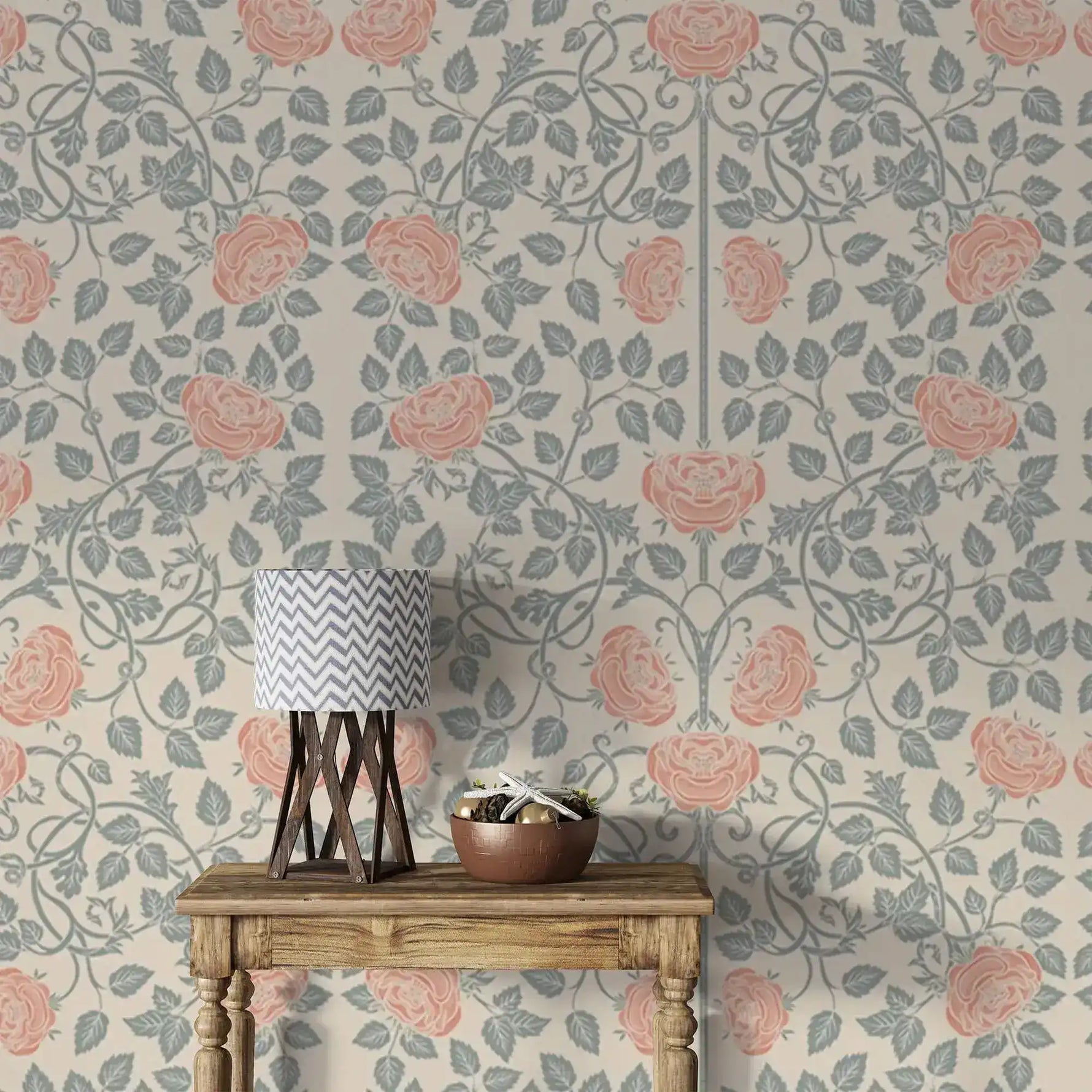 Vintage rose garden wallpaper styled with wood table and lamp, coral roses on sage vines, cream ground