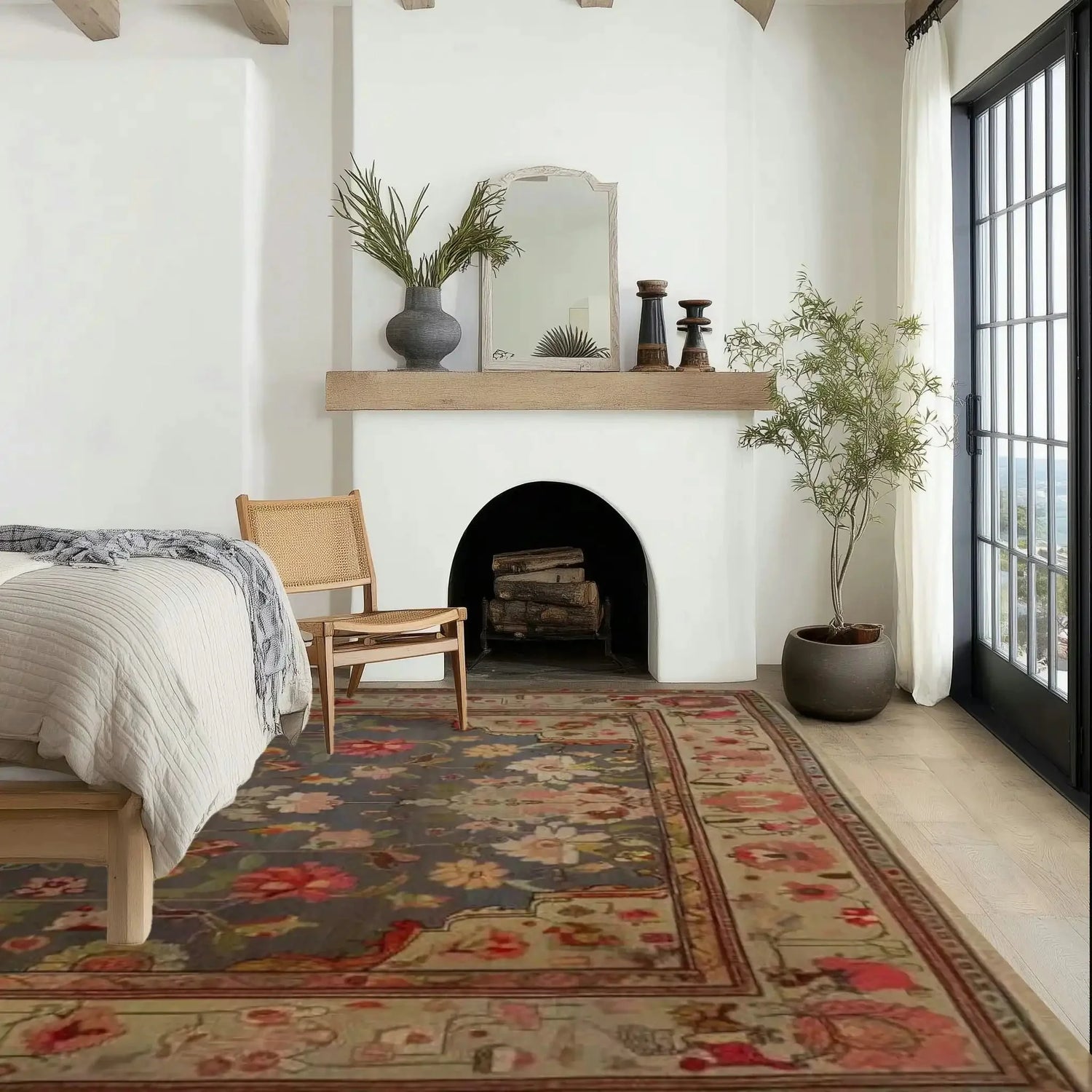 Cozy bedroom with a patterned vintage inspired persian rug, bed, chair, and fireplace.