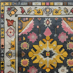 A beautifully intricate vintage tribal hand-knotted area rug featuring vibrant geometric patterns in hues of pink, yellow, and gray. This Persian rug is perfect for adding a touch of elegance to large living rooms, showcasing a harmonious blend of traditional and contemporary design elements.