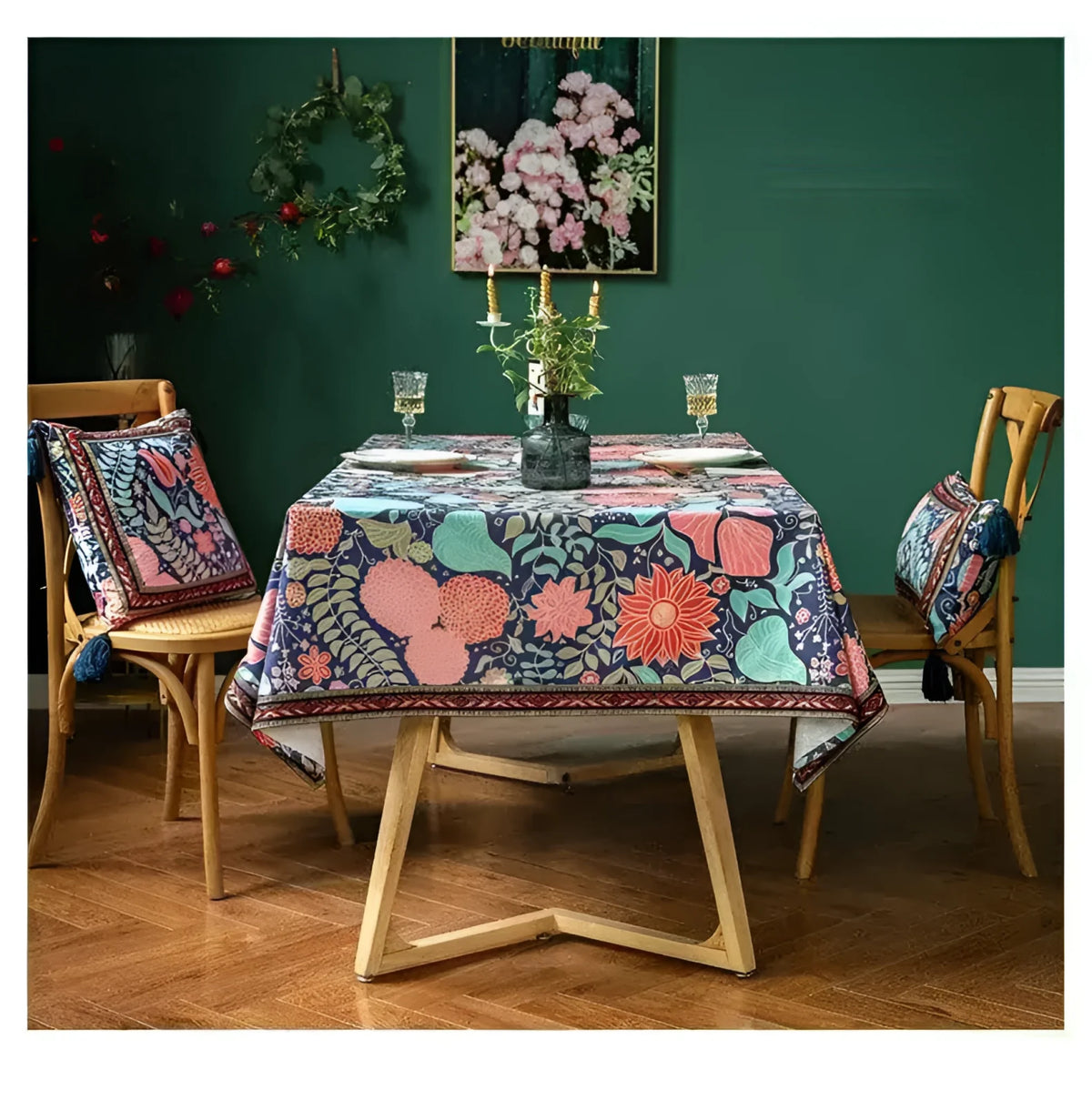 Vintage velvet floral throw pillow with tassels, enhancing a beautifully set dining table with a floral tablecloth and a green wall background.