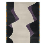 Modern office with a desk, chairs, bookshelves, a contemporary hand-tufted wool rug, and abstract art.
