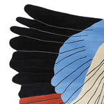 Close-up view of the Volcanic Fan Drift Hand Tufted Rug showcasing its abstract design with bold black, blue, and red patterns. This contemporary area rug, made of wool, is perfect for adding a modern touch to any living room. Ideal as a living room rug in an 8x10 size, it highlights a unique artistic flair.