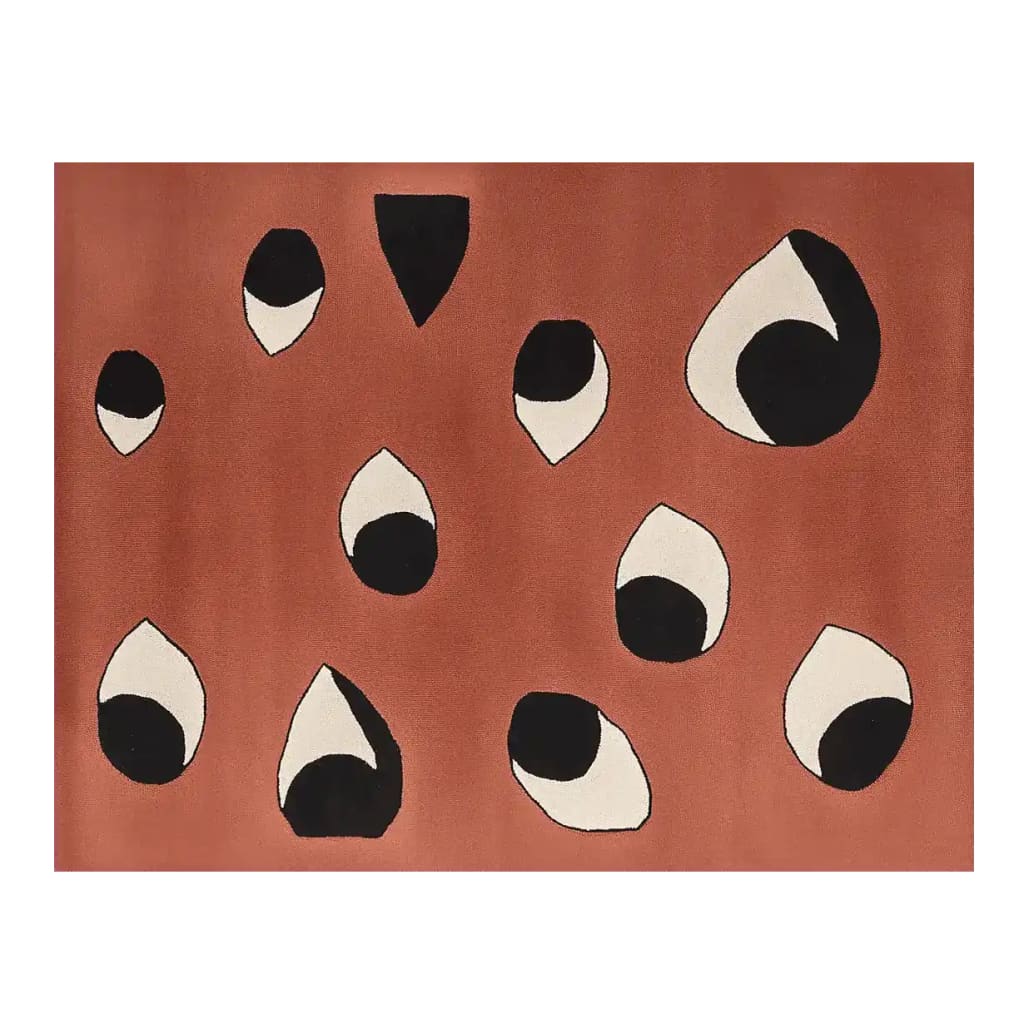 Contemporary area rug with abstract black and white eye-like patterns on a warm rust-colored background, perfect as a wool rug for modern living room area decor.