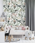 Watercolor tropical jungle wallpaper in kids room with toddler bed, pink cushions and toy pram